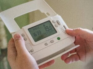 Person hält Thermostat in Händen